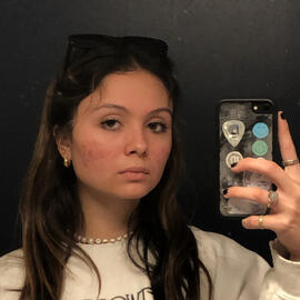 mirror selfie; dark brown hair with sunglasses holding the hair back; fleetwood mac sweatshirt on